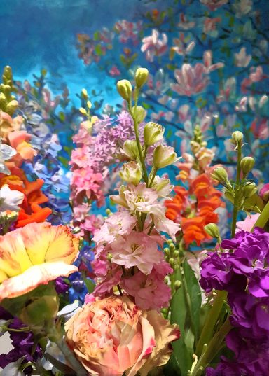 Kleurrijke bloemen in verschillende soorten en tinten met een blauwig achtergrond.